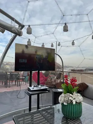 a living room with a tv and a table at Waterfront Apartment by the Tram - Terrace with Dome & Golden Horn View in Fatih in Istanbul