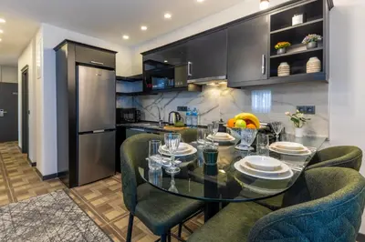 a kitchen with a glass table and chairs at BayMari Suites City Life in Istanbul