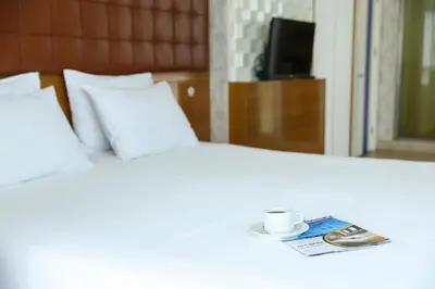 a white bed with a cup of coffee on it at The Hera Platinum Hotel in Istanbul