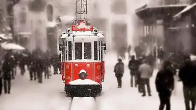 a red trolley car on a street in the snow at Taksim History Wooden Hostel in Istanbul