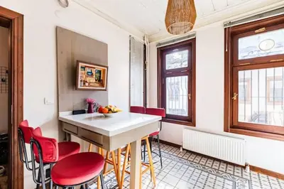 a kitchen with a table and some red chairs at Historical Greco-Ottoman Pavilion near Tram in Fatih in Istanbul