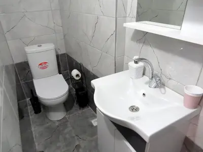 a white bathroom with a toilet and a sink at Istanberry - Royal Apartments in Istanbul
