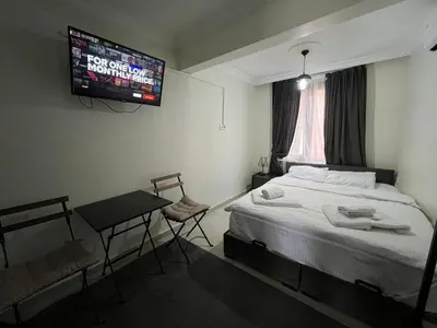 a bedroom with a bed and a tv on the wall at Mr Miller Suite in Istanbul