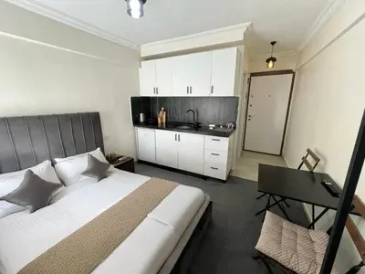 a bedroom with a large bed and a kitchen at Mr Miller Suite in Istanbul