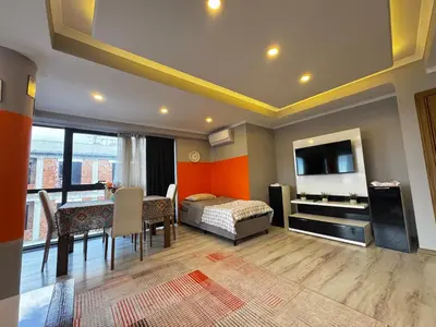 a living room with a dining table and a bedroom at Dilaver-Apart in Istanbul