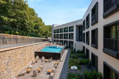an external view of a building with a pool and chairs at INVENTIST Hotel Sports Academy Istanbul in Istanbul