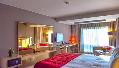 a bedroom with a bed and a living room at Denizatı Plus Hotel in Istanbul
