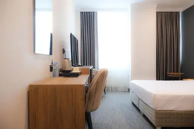 a hotel room with a bed and a desk with a desk at HOME PLUS Hotel in Istanbul