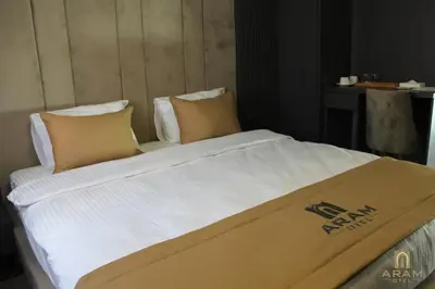 a large bed with white sheets and pillows at Aram Otel Business & Luxury in Istanbul