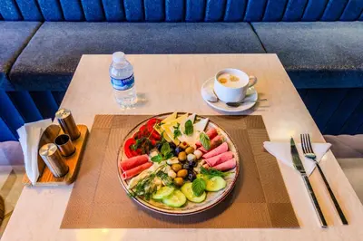 a table with a plate of food and a cup of coffee at Heaven Premium Hotel Restaurant & Airport Shuttle in Arnavutköy