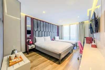 a hotel room with two beds and a desk at Heaven Premium Hotel Restaurant & Airport Shuttle in Arnavutköy