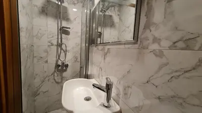 a white bathroom with a sink and a shower at Cozy Home Next to Green Mosque in Yıldırım