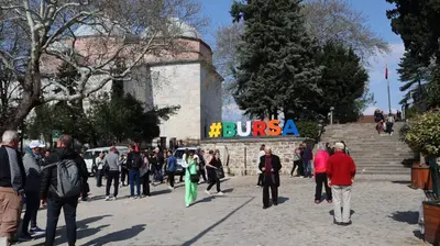 a group of people walking in front of a building at Cozy Home Next to Green Mosque in Yıldırım