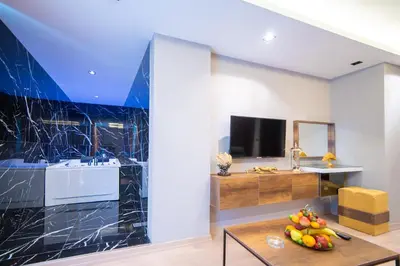 a living room with a table and a tv at Garden Room Suit Hotel in Istanbul