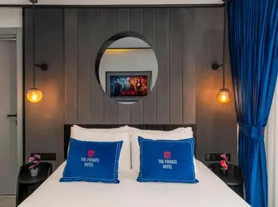 a bedroom with a bed with blue pillows and a mirror at The Private Airport Hotel in Istanbul