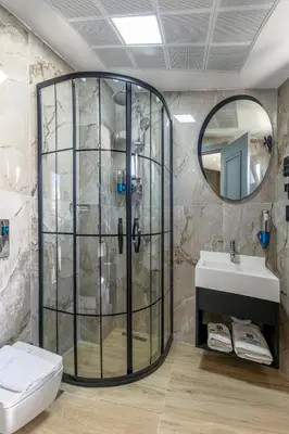 a shower in a bathroom with a sink and a mirror at The Private Airport Hotel in Istanbul