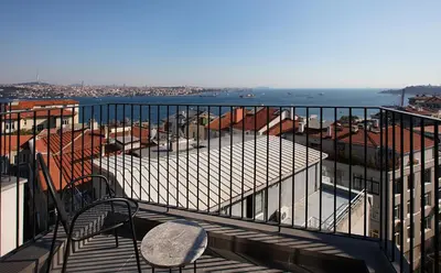 a balcony with a table and chairs on a building at Ando Living Taksim House in Istanbul