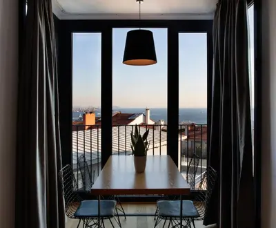 a table and chairs in front of a large window at Ando Living Taksim House in Istanbul