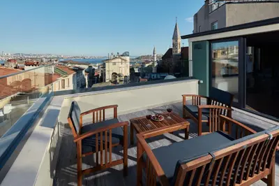 a balcony with chairs and a table on a roof at CASA GALATA 35 in Istanbul