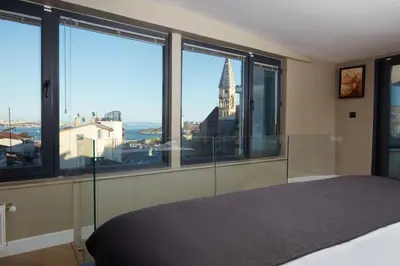 a bedroom with large windows with a view of the city at CASA GALATA 35 in Istanbul