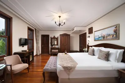 a bedroom with a large white bed and a desk at Bender Hotel in Istanbul