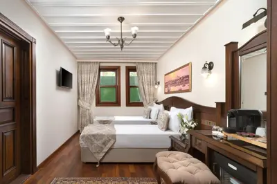 a bedroom with a bed and a desk and a television at Bender Hotel in Istanbul