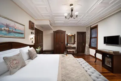 a bedroom with a large white bed and a television at Bender Hotel in Istanbul