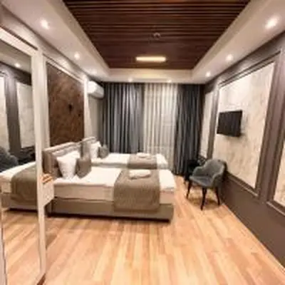 a large bedroom with a bed and a chair at Fidan City Hotel in Istanbul