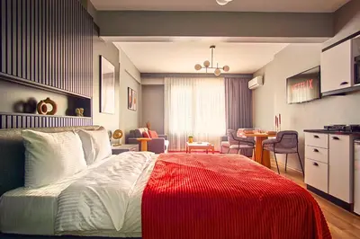 a bedroom with a bed with a red blanket on it at TAKS-INN Hotel in Istanbul