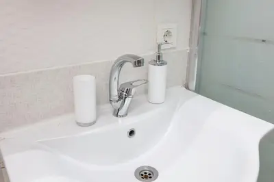 a bathroom sink with a faucet and two paper towels on it at Fidelya Boutique Hotel in Sultanahmet