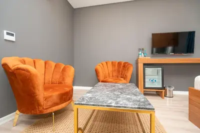 two orange chairs and a table in a living room at Center Suite in Istanbul