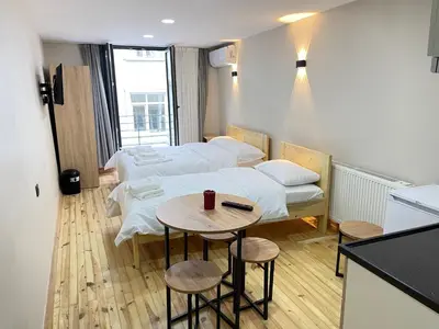 a room with two beds and a table with stools at La Perato in Istanbul