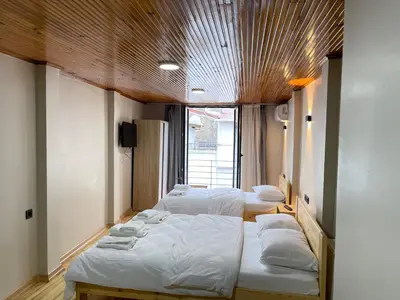 three beds in a room with a wooden ceiling at La Perato in Istanbul