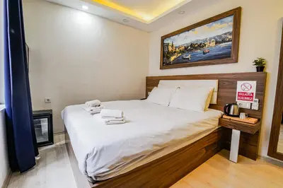 a bedroom with a large bed with white sheets at MITANI SUITES in Istanbul
