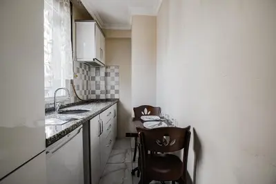 a small kitchen with a sink and two chairs at MITANI SUITES in Istanbul