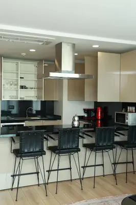 a kitchen with black chairs and a kitchen island at Lovely Two Bedroom Appartment Istanbul in Istanbul
