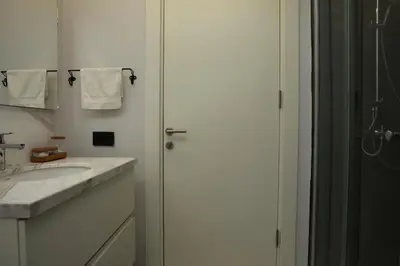 a white bathroom with a shower and a sink at Lovely Two Bedroom Appartment Istanbul in Istanbul