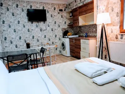 a bedroom with a bed and a table and a kitchen at Ease Inn in Istanbul