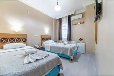 a hotel room with two beds and a flat screen tv at OTEL ÜMIT İSTANBUL in Istanbul