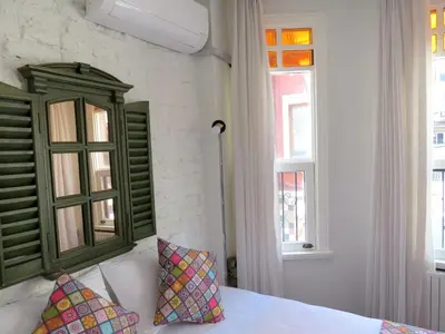 a bedroom with a bed with a green headboard and two pillows at Istanberry - Luna Apartments in Istanbul
